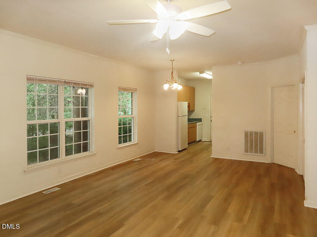 101 Rock Haven Road, Unit A100 Carrboro, NC 27510 - Photo 3 of 16 a view of an empty room with wooden floor and a window
