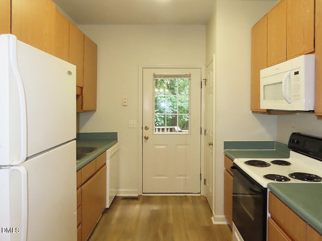 101 Rock Haven Road, Unit A100 Carrboro, NC 27510 - Photo 5 of 16 a kitchen that has a fridge and a stove in it