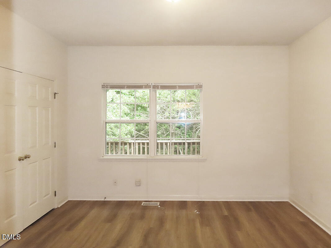 101 Rock Haven Road, Unit A100 Carrboro, NC 27510 - Photo 7 of 16 an empty room with wooden floor and windows