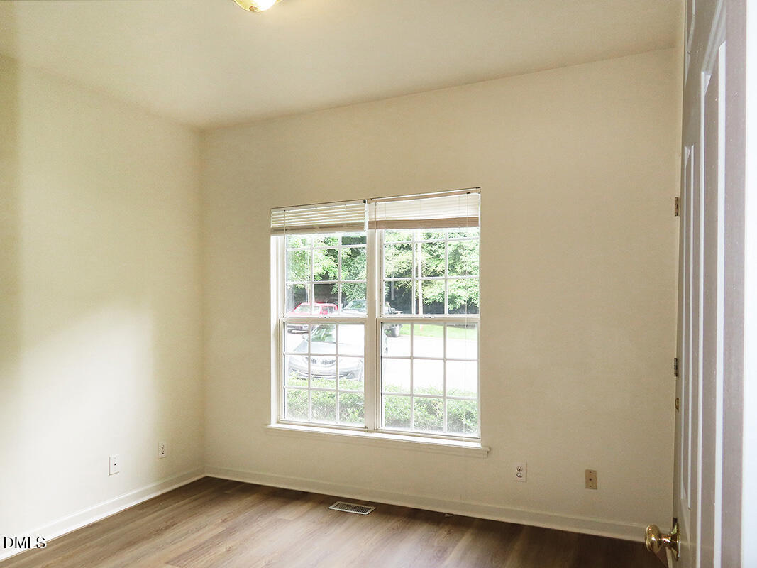 101 Rock Haven Road, Unit A100 Carrboro, NC 27510 - Photo 9 of 16 an empty room with wooden floor and windows