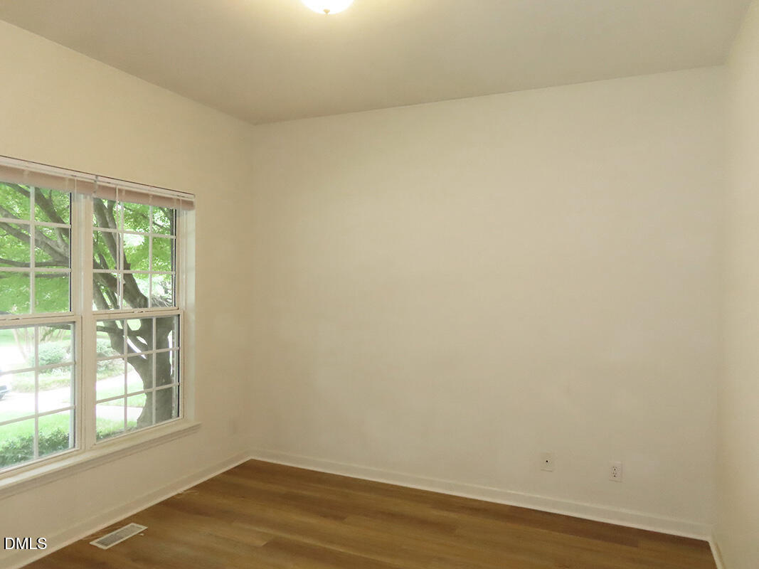 101 Rock Haven Road, Unit A100 Carrboro, NC 27510 - Photo 10 of 16 an empty room with wooden floor and windows