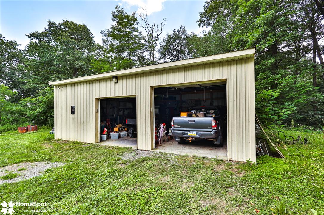 3795 Rhoades Road Kempton, PA 19529 - Photo 37 of 42 A spacious two-car garage offers ample parking and storage amidst a serene, wooded backdrop.