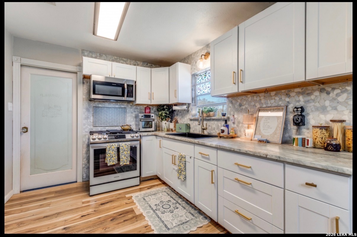 507 Stimmel Drive San Antonio, TX 78227 - Photo 3 of 7 a kitchen with granite countertop a sink and steel appliances