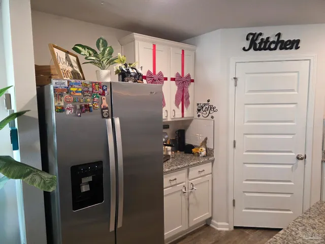 a kitchen with granite countertop a stove a sink and a refrigerator