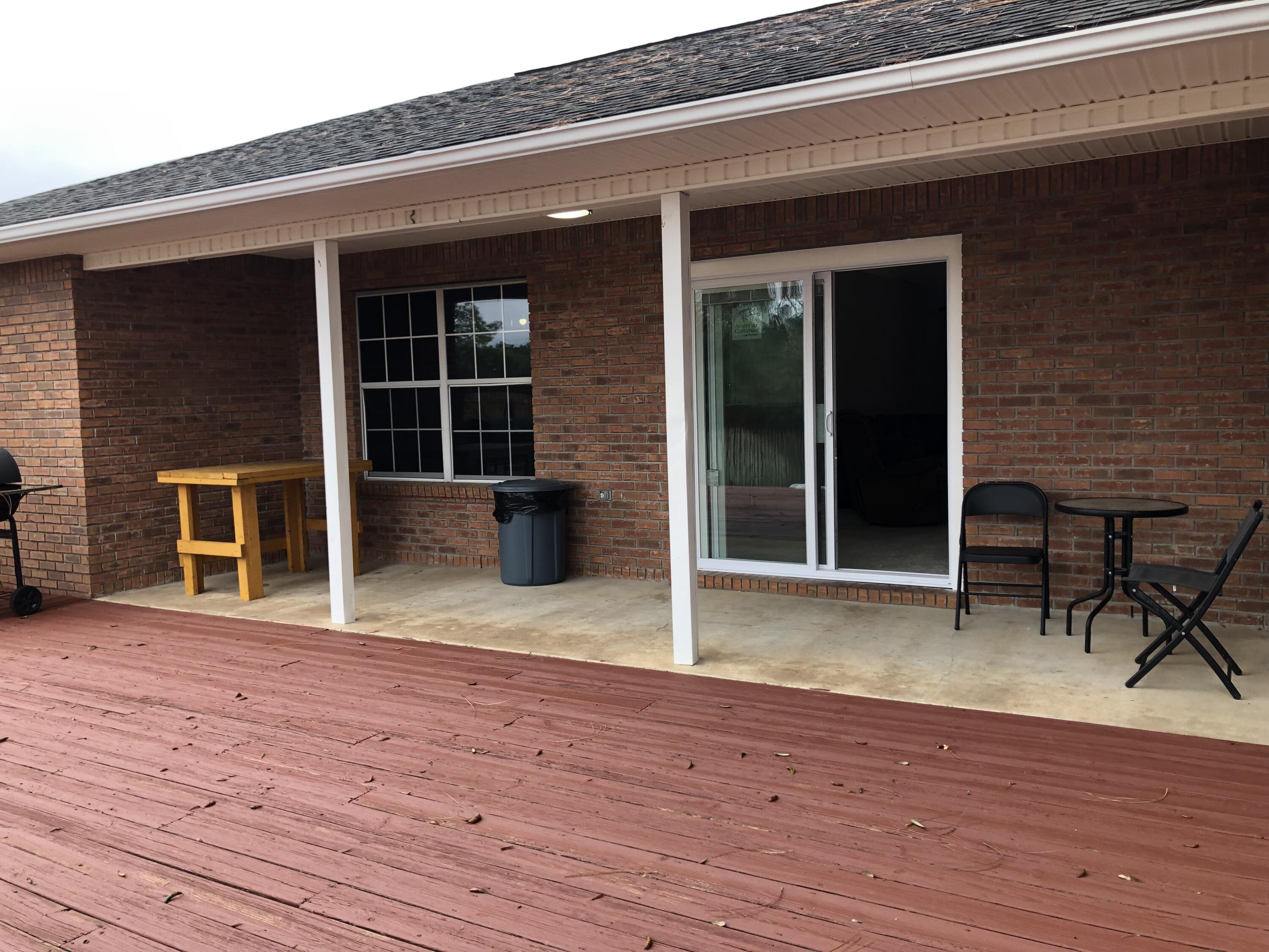 398 Riverchase Boulevard Crestview, FL 32536 - Photo 27 of 36 a view of a house with wooden deck and a floor to ceiling window
