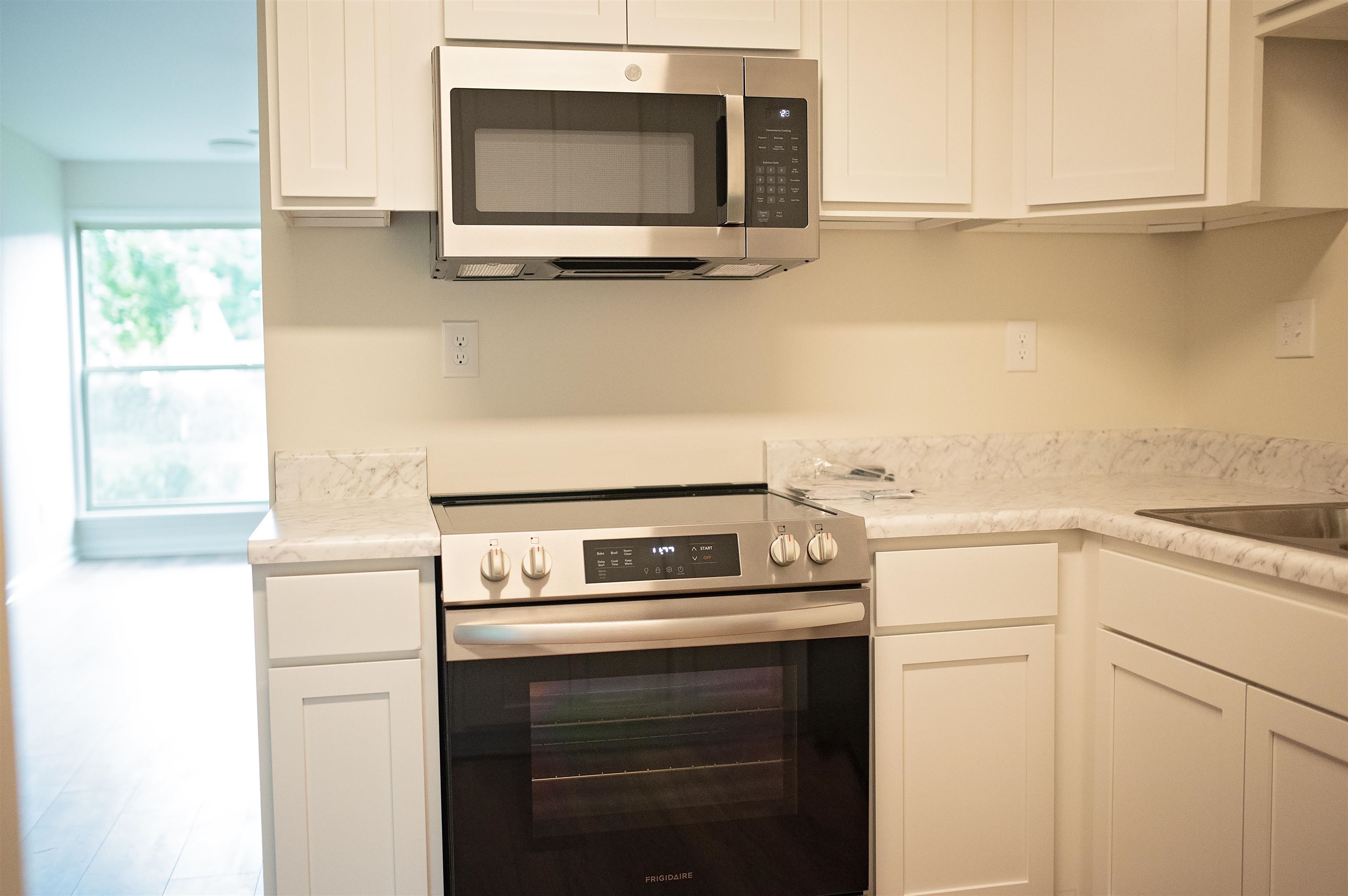 3102 Rising Sun Road, Unit 59 Lakeland, TN 38002 - Photo 16 of 27 Kitchen with white cabinets, hardwood / wood-style floors, and stainless steel appliances