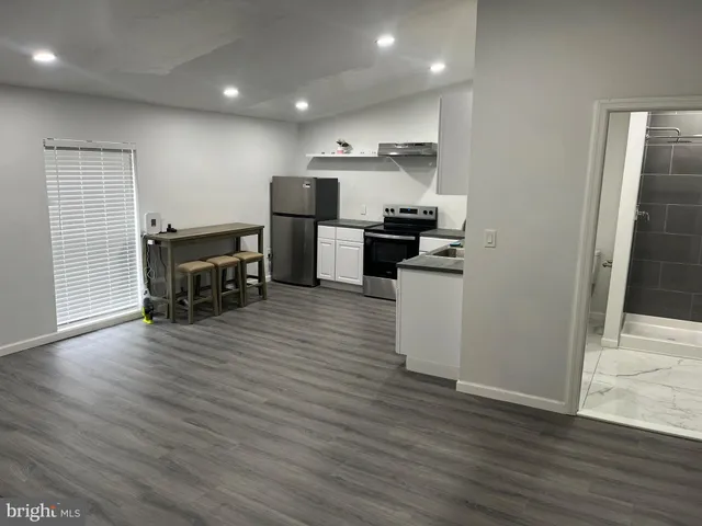 a kitchen with kitchen island wooden floors and appliances