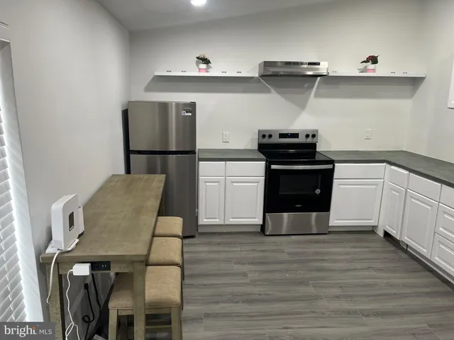 a kitchen with cabinets and wooden floor