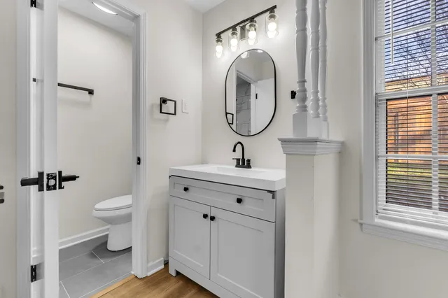 a bathroom with a toilet sink and mirror