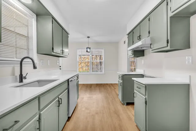 a kitchen with a sink stove and cabinets