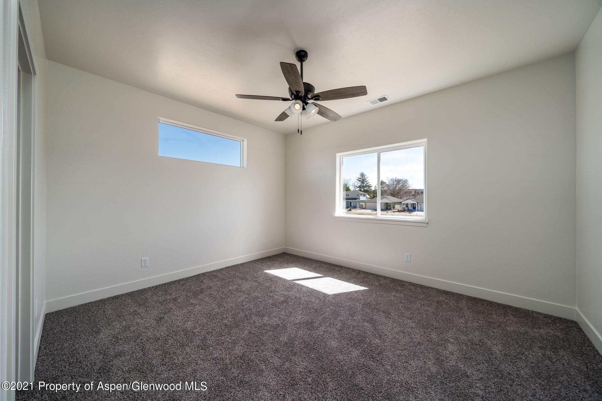 1093 East 17th Street Rifle, CO 81650 - Photo 10 of 18 en empty room with windows and ceiling fan