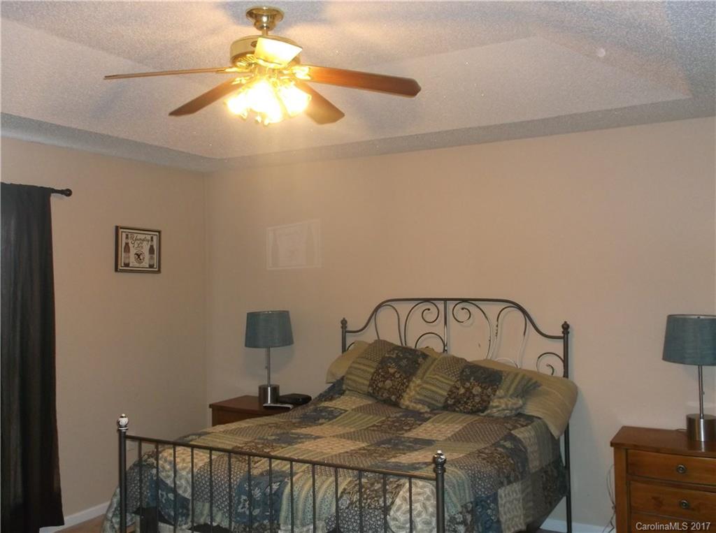 4061 Wycoff Road Sharon, SC 29742 - Photo 17 of 22 a bedroom with a bed and a chandelier