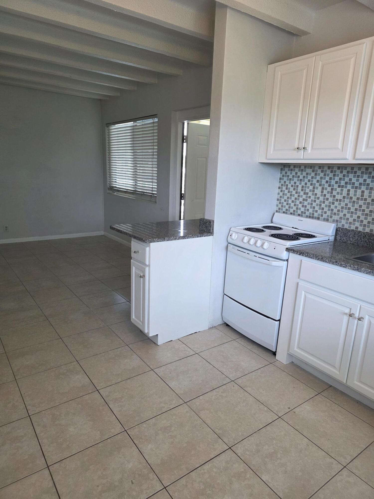 100 Cascade Lane, Unit 9 Palm Beach Shores, FL 33404 - Photo 2 of 7 a kitchen with cabinets and window