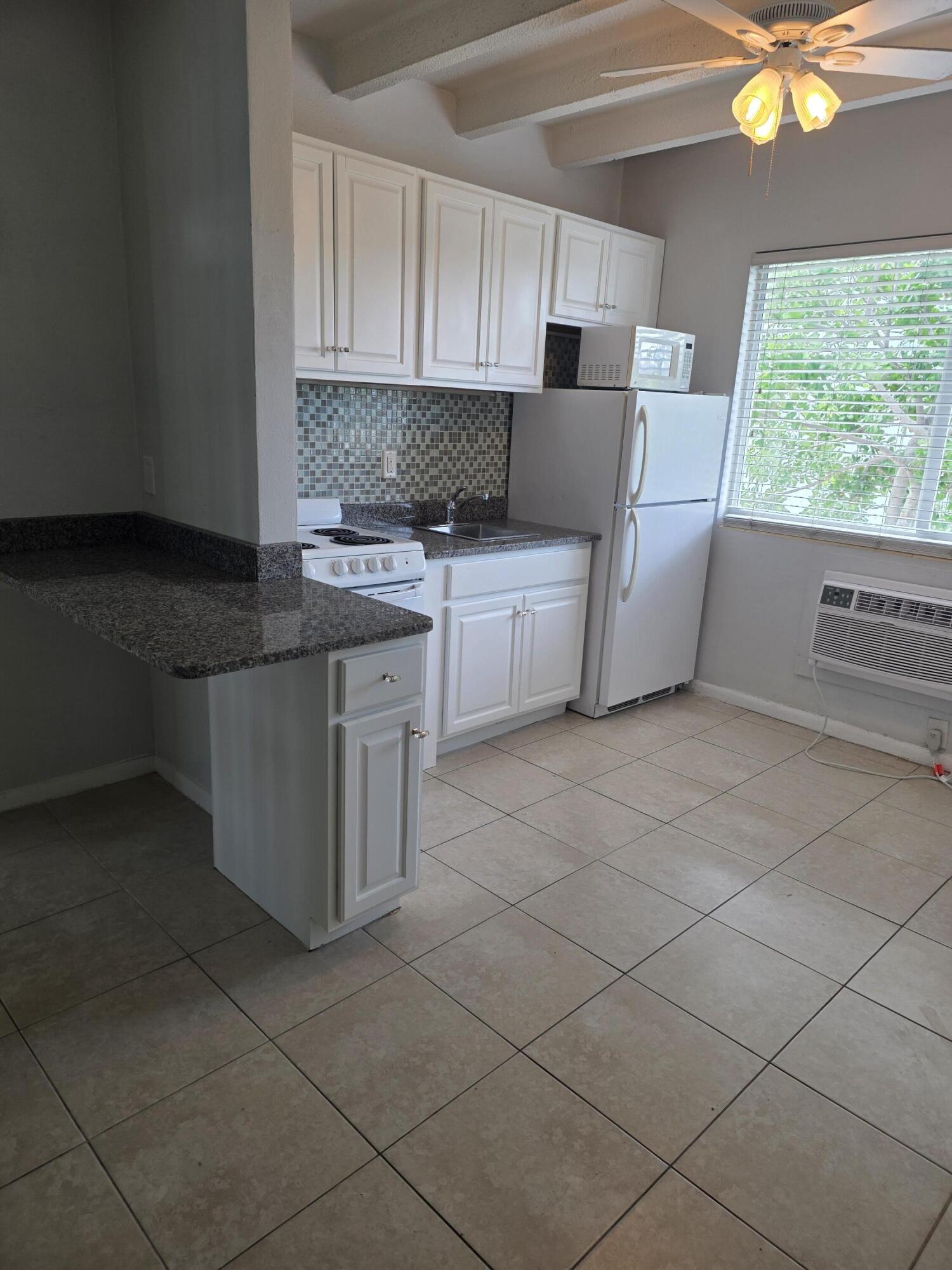 100 Cascade Lane, Unit 9 Palm Beach Shores, FL 33404 - Photo 4 of 7 a kitchen with stainless steel appliances a sink stove and cabinets