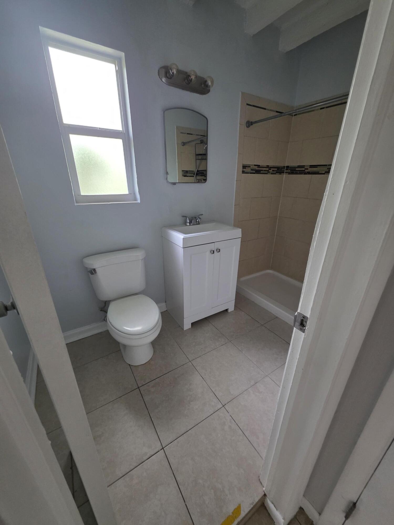 100 Cascade Lane, Unit 9 Palm Beach Shores, FL 33404 - Photo 6 of 7 a bathroom with a toilet a sink and a window