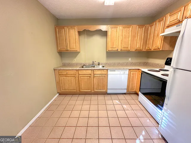 a kitchen with stainless steel appliances a sink a stove a microwave and cabinets