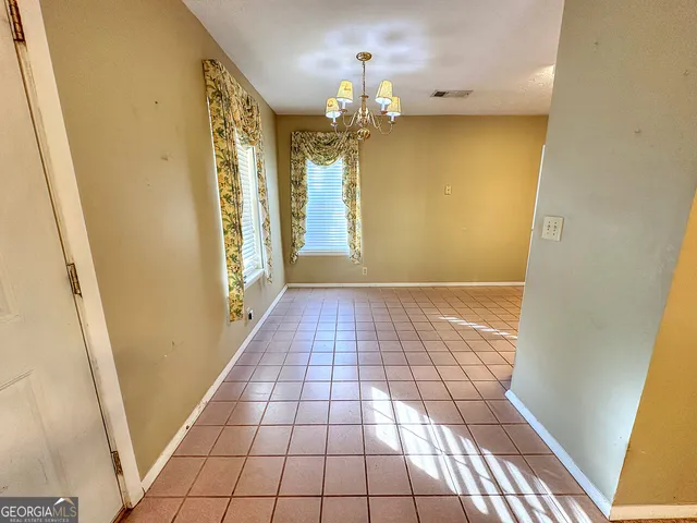 a view of a hallway view with wooden floor and chandelier