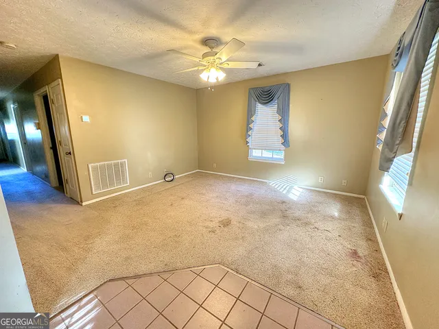 a view of an empty room with wooden floor and a chandelier