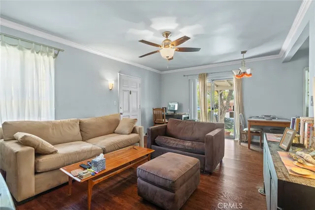 a living room with furniture a ceiling fan and a window