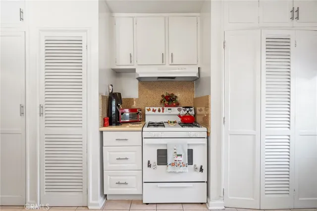 a kitchen with white cabinets and white appliances