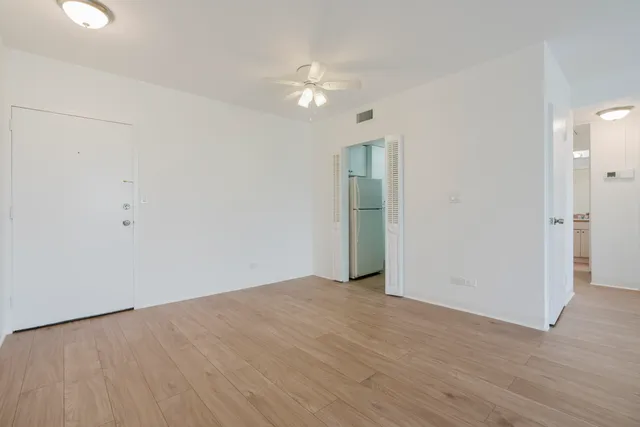 a view of an empty room with wooden floor