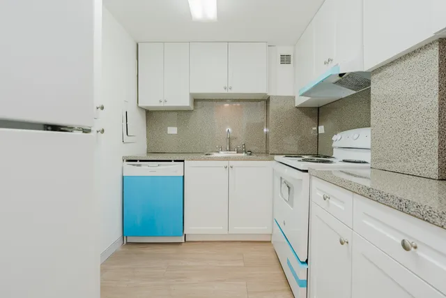 a kitchen with white cabinets and a sink