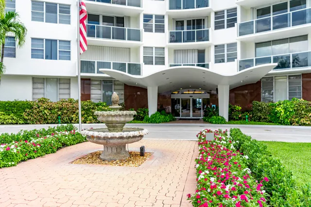 a front view of a building with garden and porch