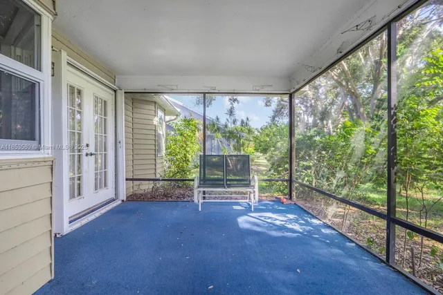 a view of empty room with wooden floor and floor to ceiling window