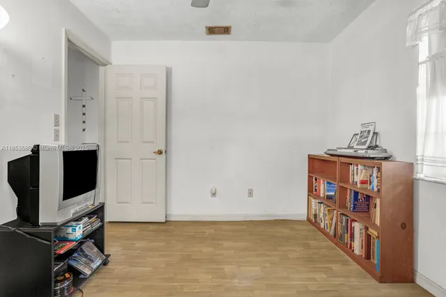 a view of an empty room with workspace and a window