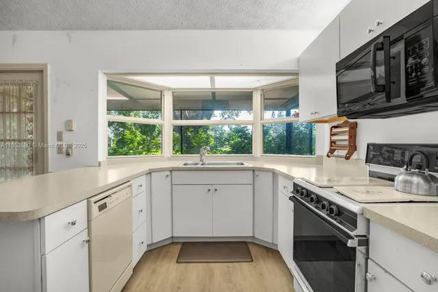 a kitchen with a sink stove and microwave