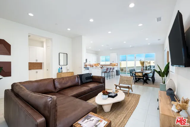 a kitchen with stainless steel appliances a table chairs sink refrigerator and cabinets