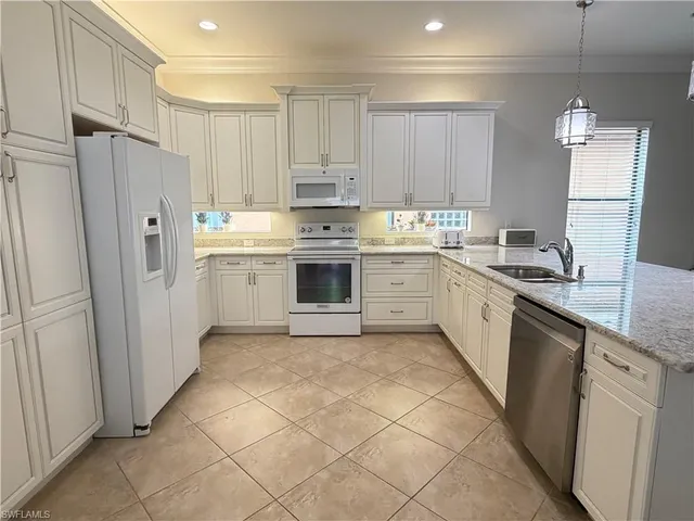 a kitchen with a sink a refrigerator and cabinets