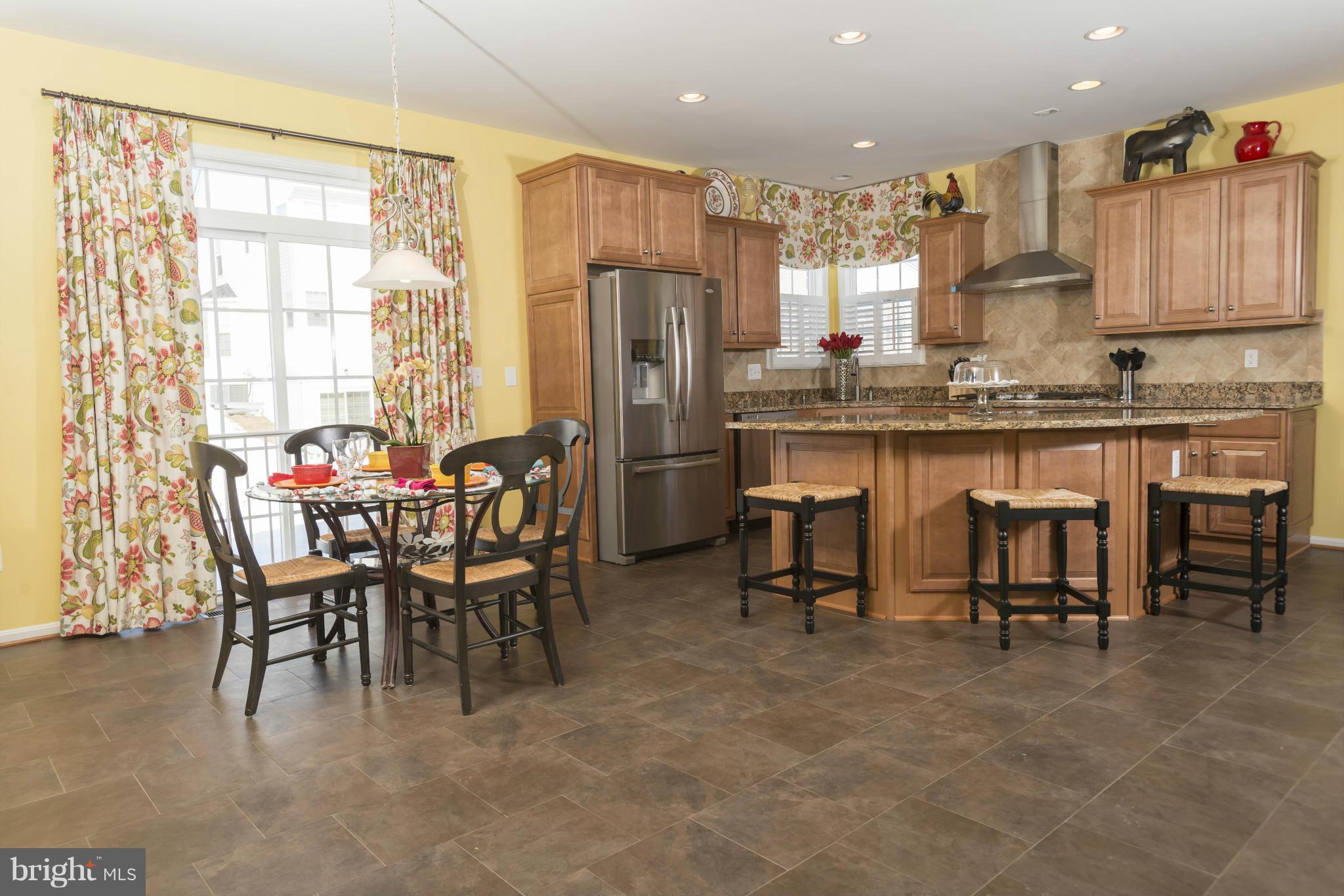 2302 Winterwood Road Baltimore, MD 21209 - Photo 12 of 30 a kitchen with stainless steel appliances granite countertop table chairs sink and cabinets