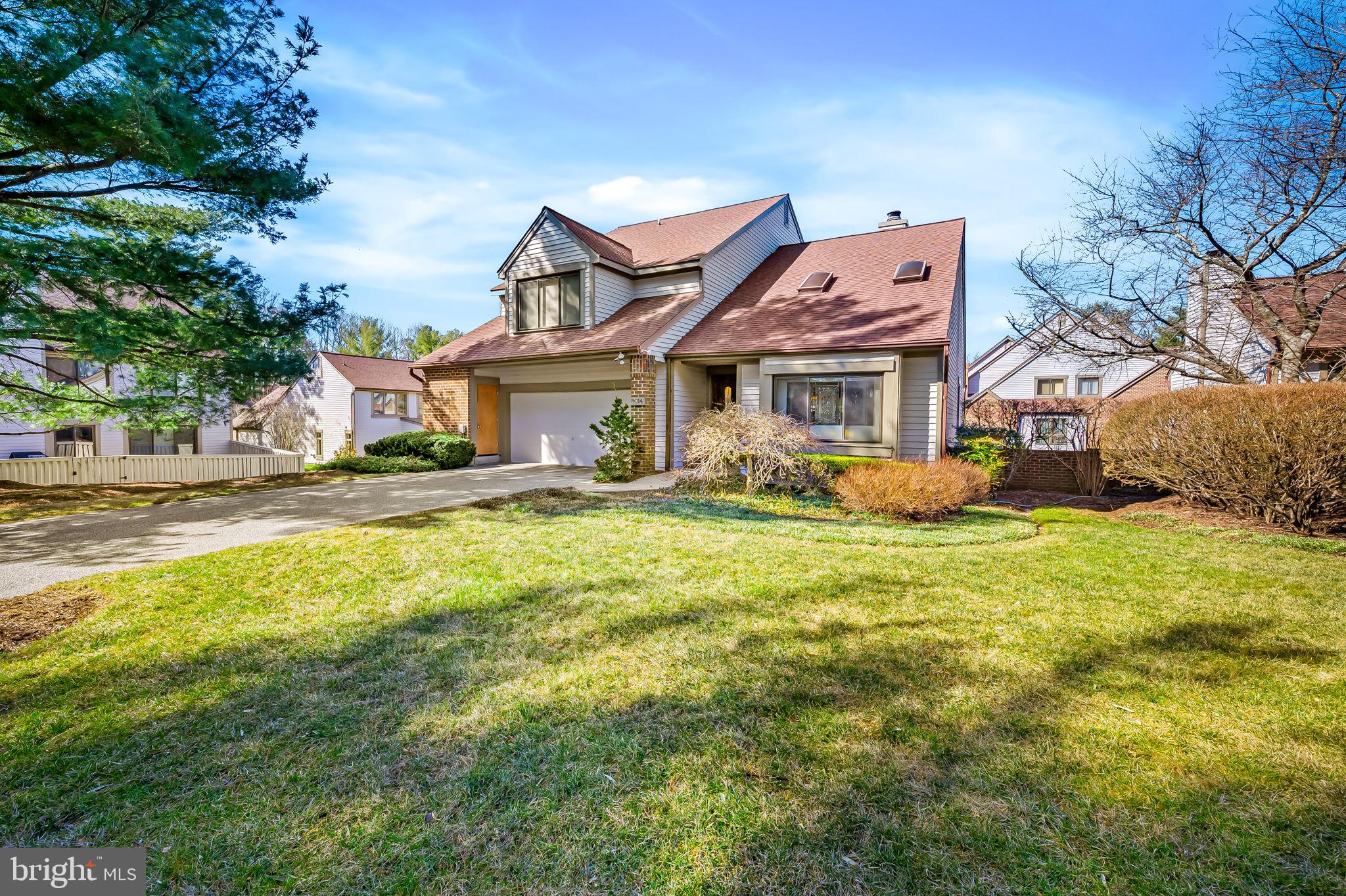 a front view of a house with a garden and plants