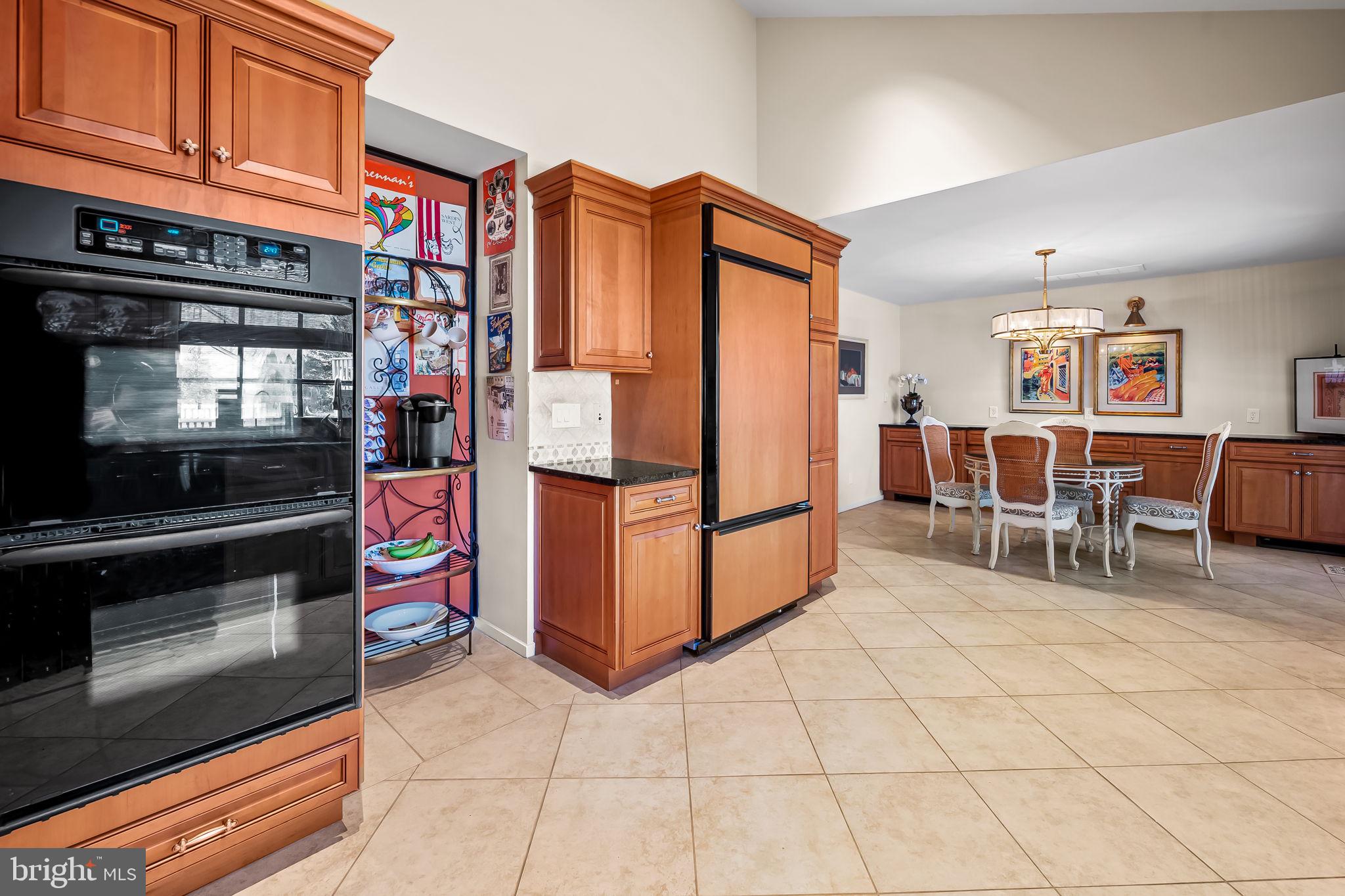 8014 Melody Lane, Unit 8014 Baltimore, MD 21208 - Photo 13 of 51 a kitchen with stainless steel appliances kitchen island granite countertop a refrigerator and cabinets