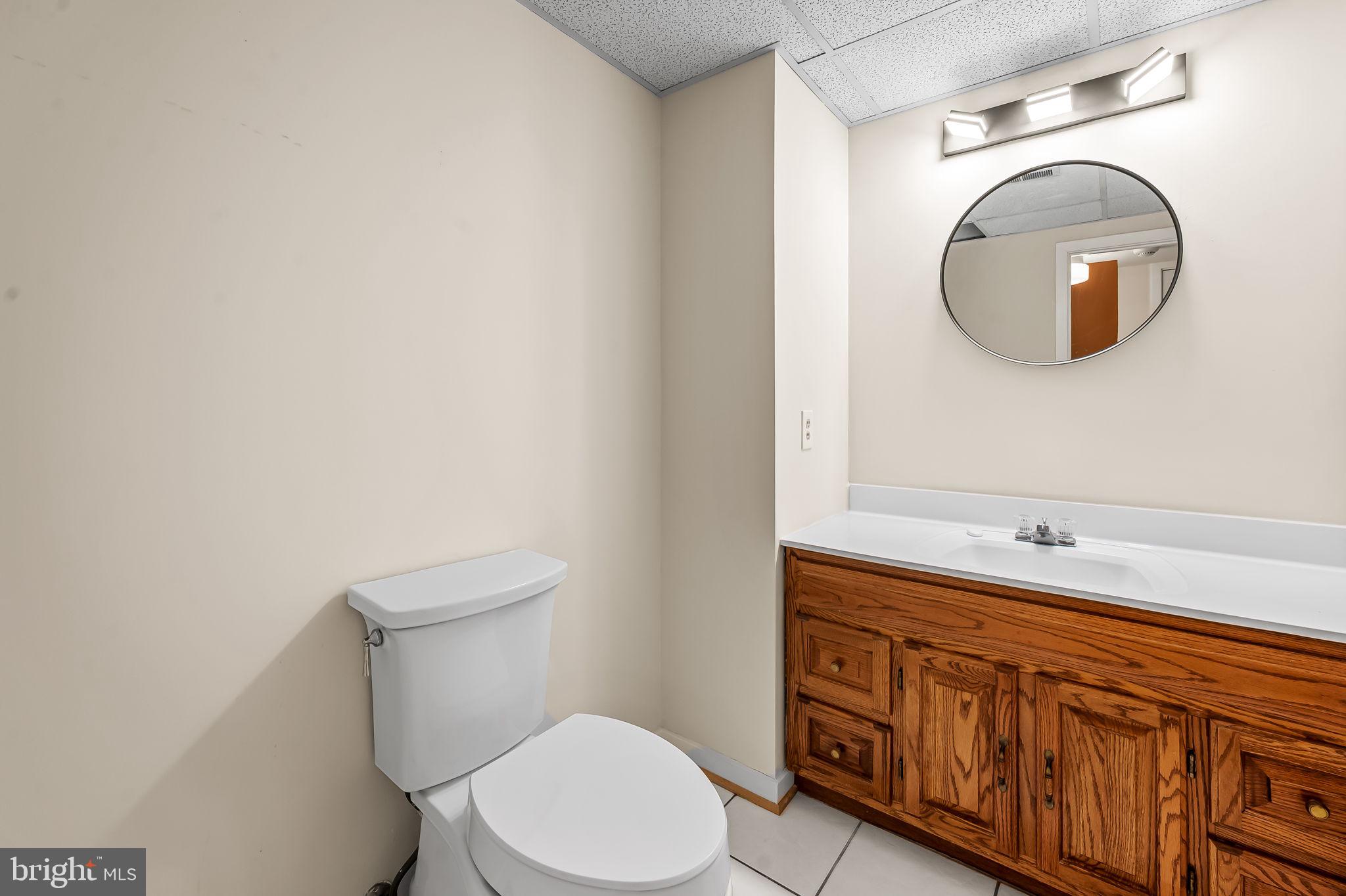 8014 Melody Lane, Unit 8014 Baltimore, MD 21208 - Photo 41 of 51 a bathroom with a toilet a sink and mirror