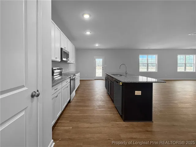 a large kitchen with stainless steel appliances granite countertop a large counter top and a stove top oven