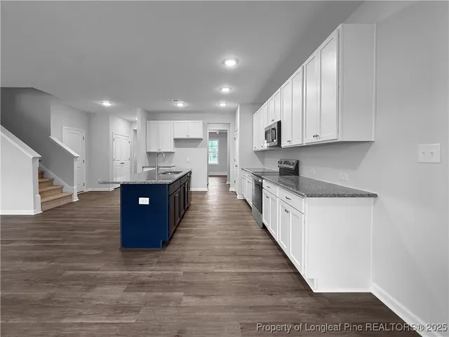 a kitchen with white cabinets and stainless steel appliances