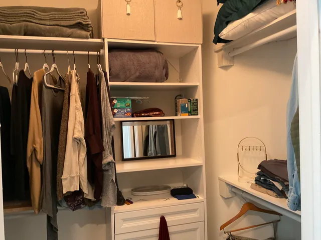 a view of walk in closet with clothes and shoes