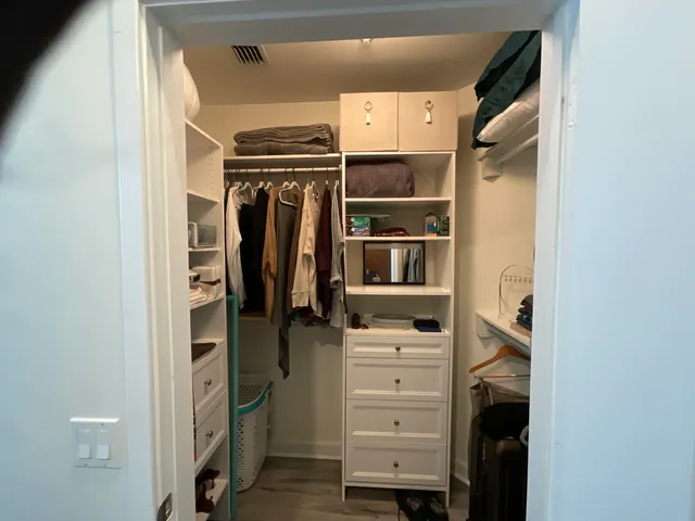 a view of walk in closet with clothes and shoes