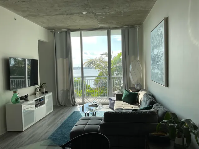 a living room with furniture and a floor to ceiling window