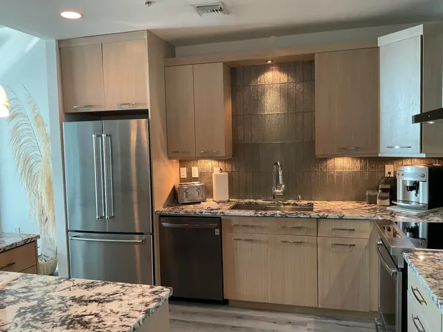 a kitchen with stainless steel appliances granite countertop a refrigerator sink and stove