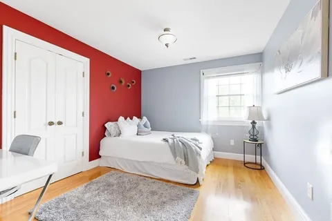 a bedroom with a bed and wooden floor