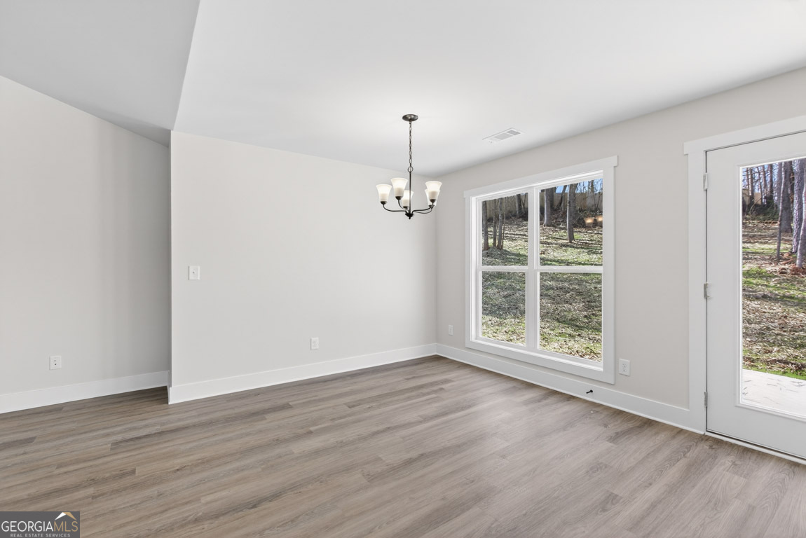 230 Airport Road, Unit 9 Canon, GA 30520 - Photo 6 of 36 an empty room with wooden floor cabinet and windows