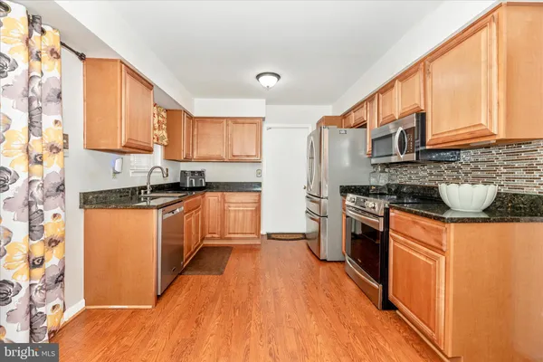 a kitchen with stainless steel appliances granite countertop a stove a sink dishwasher and a refrigerator