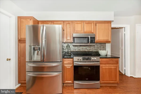 a kitchen with stainless steel appliances granite countertop a refrigerator stove and microwave