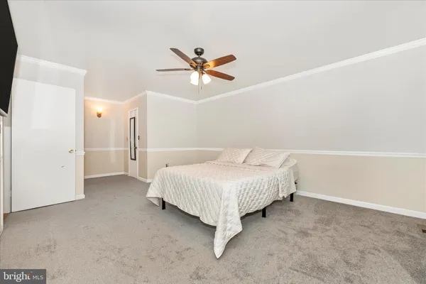 a spacious bedroom with a bed and a ceiling fan