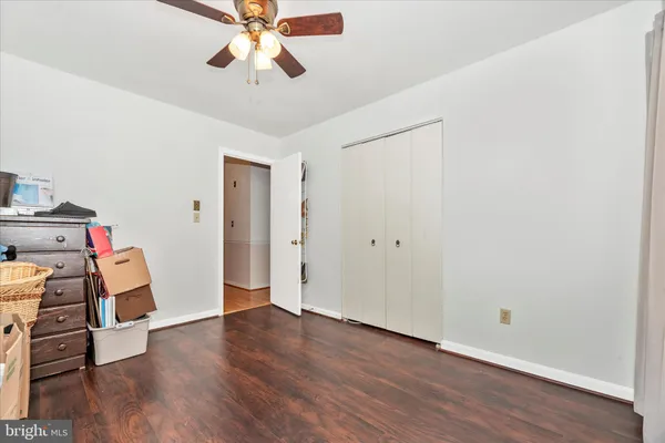 an empty room with wooden floor closet and windows