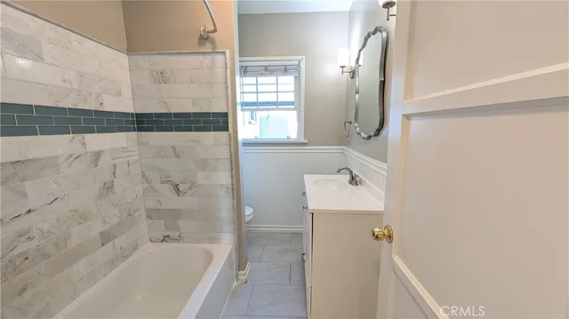 a bathroom with a bathtub sink and mirror