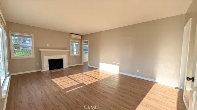 a view of a livingroom with wooden floor and a fireplace